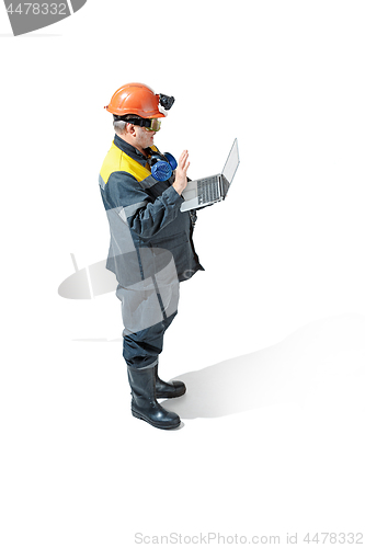 Image of The studio shot of senior bearded male miner standing at the camera on a white background.