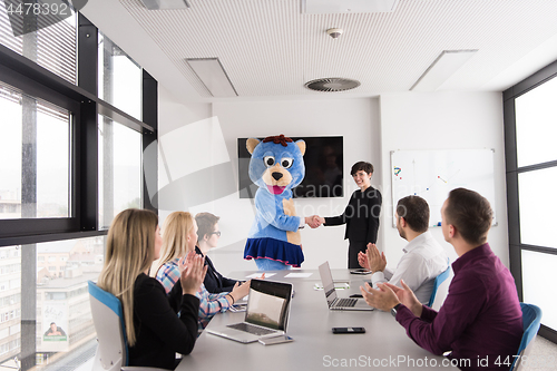 Image of boss dresed as bear having fun with business people in trendy of