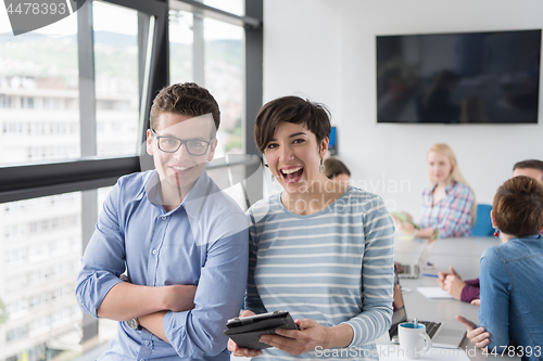 Image of Two Business People Working With Tablet in office