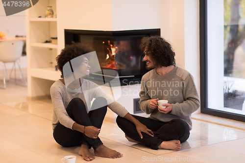 Image of multiethnic couple  in front of fireplace