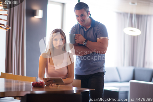 Image of couple using tablet at home