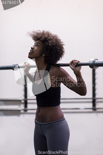 Image of black woman lifting empty bar