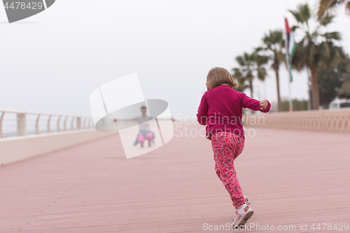 Image of mother and cute little girl on the promenade by the sea