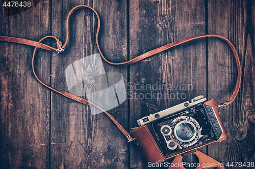 Image of Old retro vintage camera on grunge wooden background