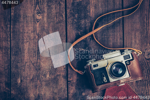 Image of Old retro vintage camera on grunge wooden background