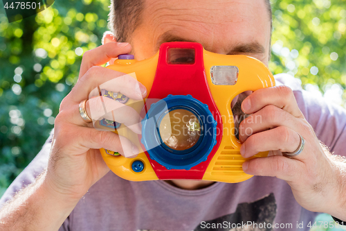 Image of Man with a toy photocamera