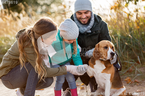 Image of happy family with beagle dog outdoors in autumn