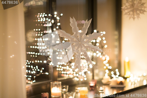 Image of paper snowflake decoration hanging on window