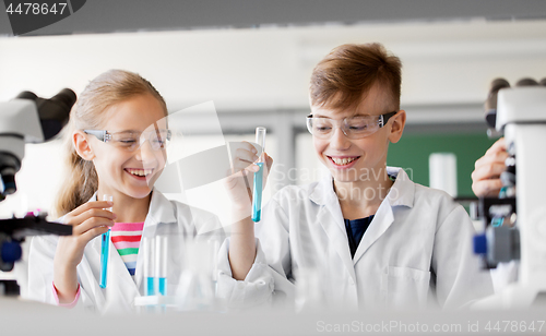 Image of kids with test tubes studying chemistry at school