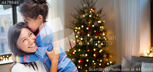 Image of happy mother hugging her daughter on christmas