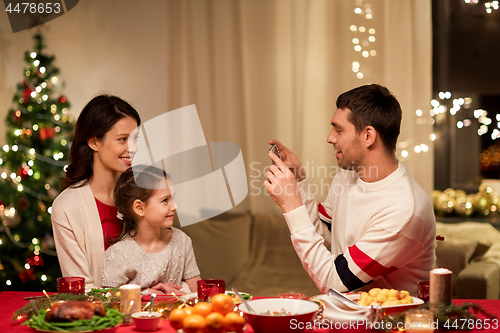 Image of happy family taking picture at christmas dinner