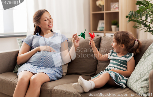 Image of pregnant mother and daughter with crane origami