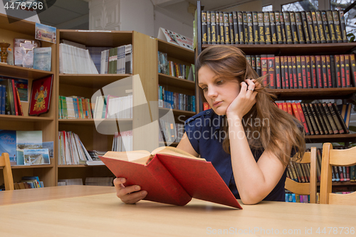 Image of A library visitor reads a book in a library