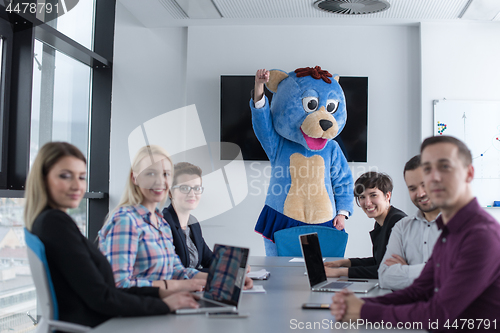 Image of boss dresed as bear having fun with business people in trendy of