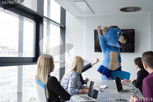 Image of boss dresed as bear having fun with business people in trendy of