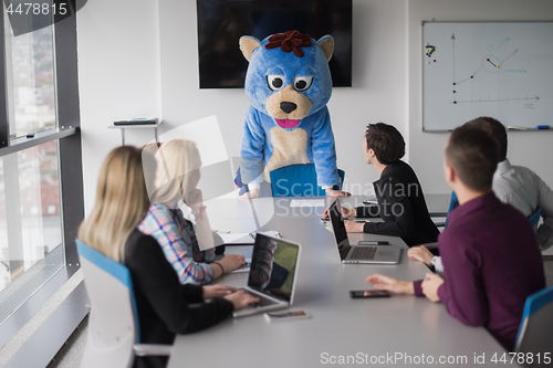 Image of boss dresed as bear having fun with business people in trendy of