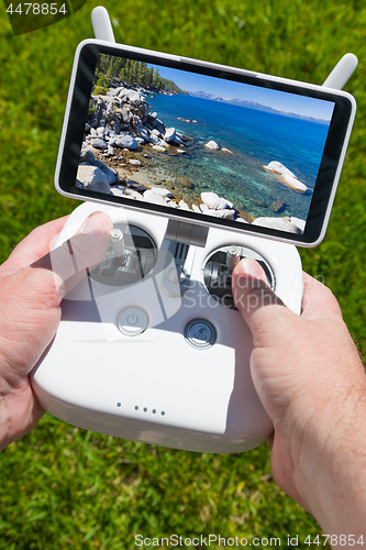 Image of Hands Holding Drone Quadcopter Controller With Beautiful Lake Vi