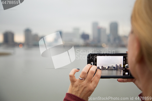 Image of Woman Taking Pictures of The New Orleans Skyline with Her Smart 