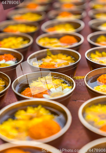 Image of Buddhist flower offerings or gifts in bowls and rows