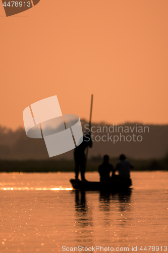 Image of Blurred Men in a boat on a river silhouette