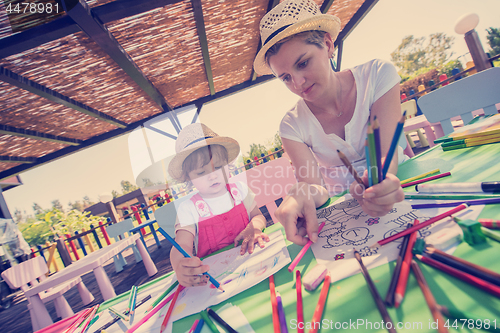 Image of mom and little daughter drawing a colorful pictures