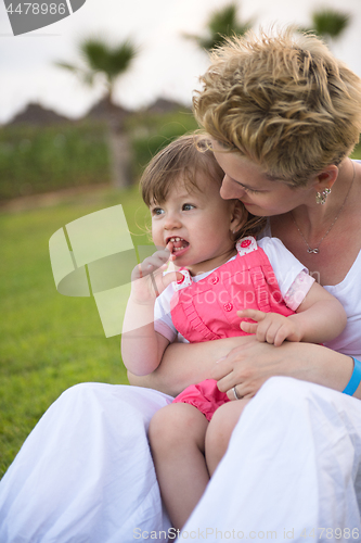 Image of mother and little daughter playing at backyard