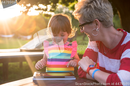 Image of mom and her little daughter using tablet computer