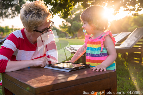 Image of mom and her little daughter using tablet computer