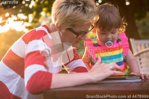 Image of mom and her little daughter using tablet computer