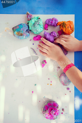 Image of kid hands Playing with Colorful Clay