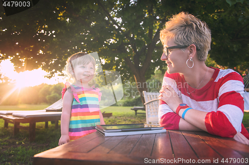 Image of mom and her little daughter using tablet computer