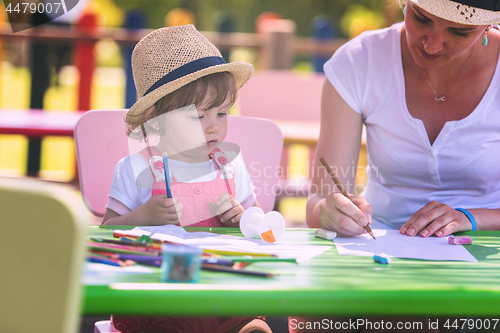 Image of mom and little daughter drawing a colorful pictures