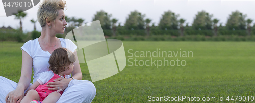 Image of mother and little daughter playing at backyard