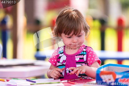 Image of little girl drawing a colorful pictures