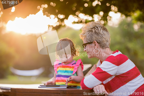 Image of mom and her little daughter using tablet computer