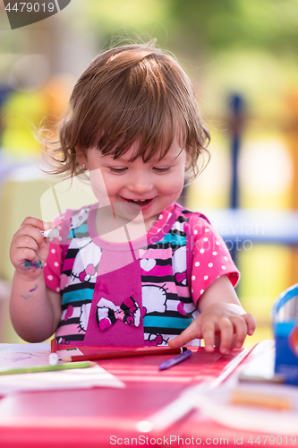 Image of little girl drawing a colorful pictures