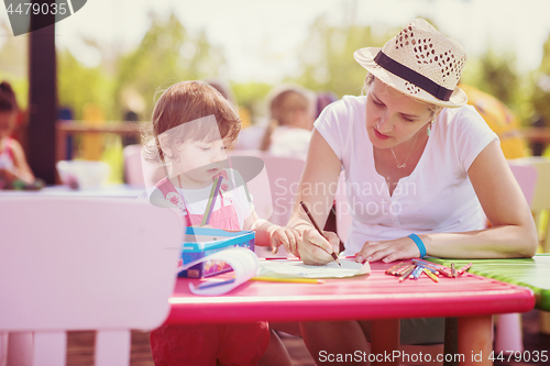 Image of mom and little daughter drawing a colorful pictures