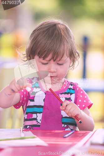 Image of little girl drawing a colorful pictures