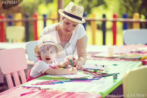 Image of mom and little daughter drawing a colorful pictures