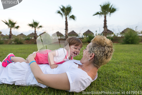 Image of mother and little daughter playing at backyard