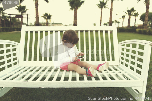 Image of little girl playing with mobile phone