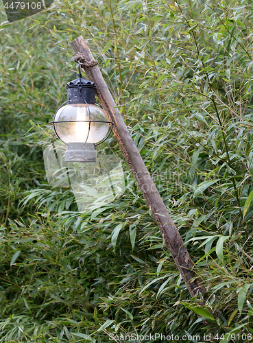 Image of Old lantern hanging on a wooden pole