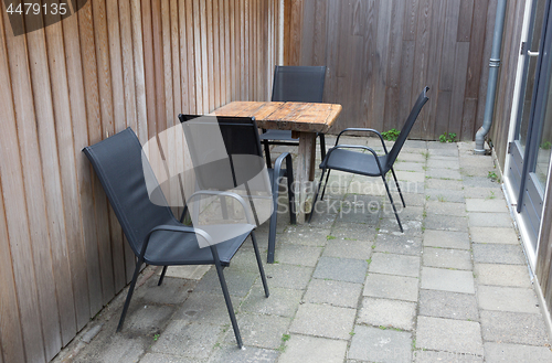 Image of Table and chairs In small stone garden