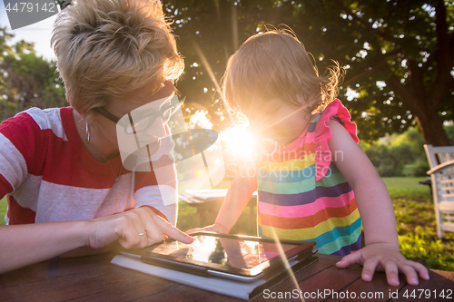 Image of mom and her little daughter using tablet computer