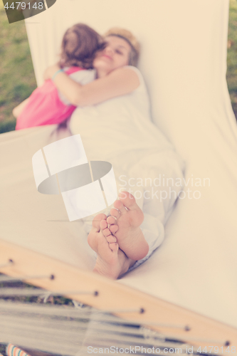 Image of mother and a little daughter relaxing in a hammock