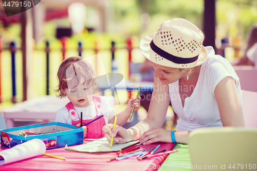 Image of mom and little daughter drawing a colorful pictures