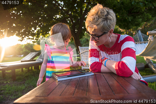 Image of mom and her little daughter using tablet computer