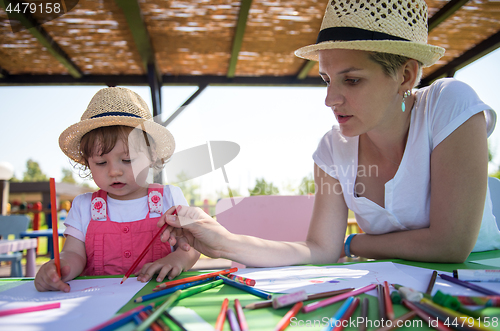 Image of mom and little daughter drawing a colorful pictures