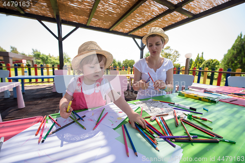 Image of mom and little daughter drawing a colorful pictures