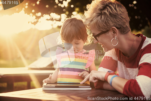 Image of mom and her little daughter using tablet computer